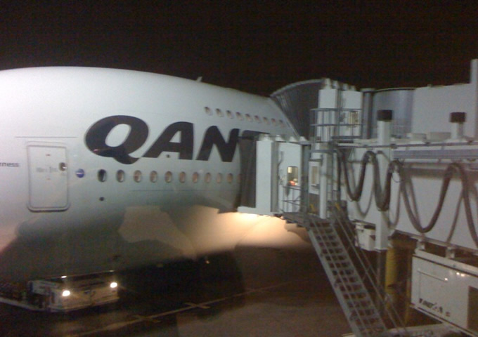 Qantas Airbus A380 At Airport Terminal At LAX - Notice The Two Jet Walkways Connected To The Airbus As The Double Decker Airliner Has An Upper Deck Door And A Lower Deck Door